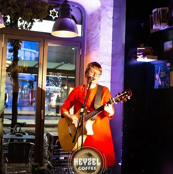 Live-Musikerin mit Gitarre vor Heyzel Coffee