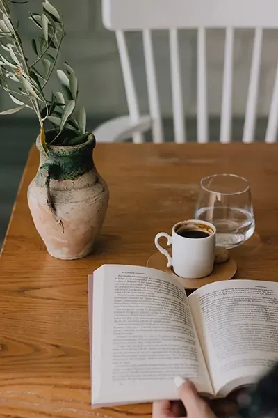 Kaffee und Buch auf Holztisch bei Heyzel